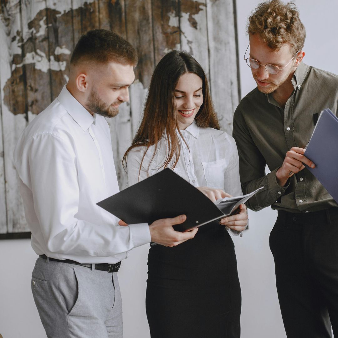 Zespół w biurze omawia dokumenty – przygotowanie współpracowników na przyjęcie nowej osoby do zespołu